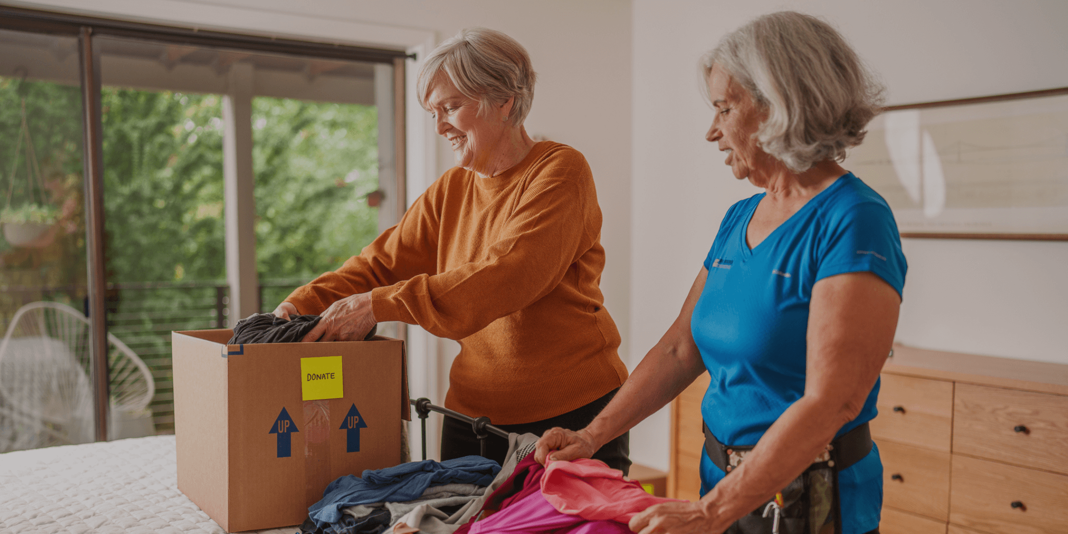 Professional organizer working with a client on her closet organizing and donation box
